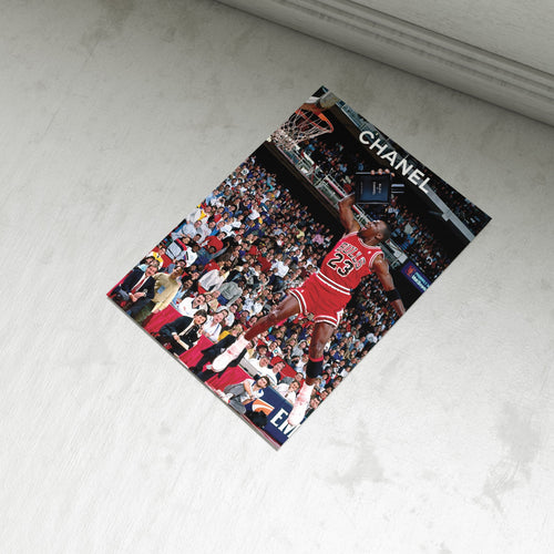 Basketball poster with a player in a red jersey on a light gray surface, featuring the brand 'Chanel'.